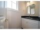 Well-lit bathroom with a white vanity, dark countertop, and a sleek, modern mirror at 10483 St Anne Dr, Zionsville, IN 46077