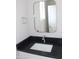 Bathroom vanity with a black countertop, modern faucet, and a framed mirror with decorative towel holder at 10483 St Anne Dr, Zionsville, IN 46077