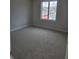 Empty bedroom with neutral carpet, window, and view of outside, ideal for customization and showcasing the home's potential at 10483 St Anne Dr, Zionsville, IN 46077