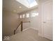 Bright hallway with natural light from skylight, featuring a wooden staircase at 10483 St Anne Dr, Zionsville, IN 46077