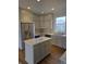 Well-equipped kitchen with a central island, stainless steel refrigerator, and ample cabinet space at 10483 St Anne Dr, Zionsville, IN 46077