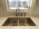Close-up of a modern kitchen sink with stainless steel faucet and a window view at 10483 St Anne Dr, Zionsville, IN 46077