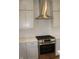 Gourmet kitchen with stainless steel range hood, gas cooktop, and bright white tile backsplash at 10483 St Anne Dr, Zionsville, IN 46077