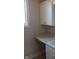 A well-lit laundry room featuring white cabinets, a sleek countertop, and a window, highlighting practical design elements at 10483 St Anne Dr, Zionsville, IN 46077