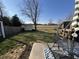 Sunny backyard view with patio set, lawn and a shed against the back fence at 1217 Meadowood Dr, Danville, IN 46122