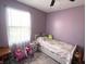 Bright bedroom with purple walls, white trim, neutral area rug and white sheer curtains at 1217 Meadowood Dr, Danville, IN 46122
