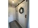 Hallway featuring a sliding barn door, view of the front door, wood floors, and a patterned rug at 1217 Meadowood Dr, Danville, IN 46122