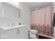 Bathroom with pink floral shower curtain, white vanity, and updated sink at 1224 N Olney St, Indianapolis, IN 46201