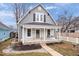 Attractive gray home with a quaint front porch and a beautifully landscaped front yard at 1224 N Olney St, Indianapolis, IN 46201