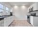 Well-lit kitchen features stainless steel appliances, white cabinetry, and wood-look flooring at 1224 N Olney St, Indianapolis, IN 46201