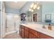 Bright bathroom featuring a double sink vanity with modern fixtures, a glass door shower, and soft blue walls at 1225 Middlebury Dr, Westfield, IN 46074