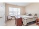 Cozy bedroom with a queen-sized bed, side table, adjacent desk, and a sun-filled window providing pleasant natural light at 1225 Middlebury Dr, Westfield, IN 46074