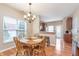 Bright dining area features wood floors, chandelier, and a view into the kitchen at 1225 Middlebury Dr, Westfield, IN 46074