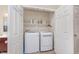 Convenient laundry closet featuring a full-sized washer and dryer, with shelving for storage and easy accessibility at 1225 Middlebury Dr, Westfield, IN 46074