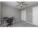 Grey carpeted bedroom featuring an office desk with a ceiling fan and closet doors at 13446 N Carwood Ct, Camby, IN 46113