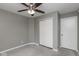 Grey carpeted bedroom featuring a ceiling fan, and closet doors at 13446 N Carwood Ct, Camby, IN 46113