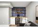 Stylish basement bar area featuring blue tile, wooden shelves, cabinets, and wine storage at 1422 Carrollton Ave, Indianapolis, IN 46202