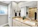 Bathroom with dual sinks, granite vanity, mirror, and adjacent tile shower at 1422 Carrollton Ave, Indianapolis, IN 46202