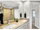 Bathroom with dual sinks, granite vanity, mirror, and adjacent tile shower at 1422 Carrollton Ave, Indianapolis, IN 46202