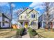 Charming two-story home featuring a bright yellow door and well-manicured landscaping at 1422 Carrollton Ave, Indianapolis, IN 46202