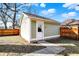 Detached garage with a white door and exterior lighting in the backyard at 1422 Carrollton Ave, Indianapolis, IN 46202