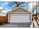 Garage with a large white door and exterior lighting with a view of a mature tree in the front at 1422 Carrollton Ave, Indianapolis, IN 46202