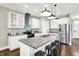 Modern kitchen boasts stainless steel appliances, a center island with seating and pendant lighting at 1422 Carrollton Ave, Indianapolis, IN 46202