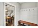 Mudroom with hooks, bench and view into adjacent dining room at 1422 Carrollton Ave, Indianapolis, IN 46202
