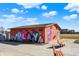 A colorful restroom building with playful mural designs and benches nearby in a public park at 1422 Carrollton Ave, Indianapolis, IN 46202