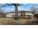 View of the backyard with a wooden deck, mature trees, and a partially fenced yard at 1611 Elmhurst Dr, Indianapolis, IN 46219