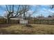 Spacious backyard featuring a storage shed, fire pit, and mature trees at 1611 Elmhurst Dr, Indianapolis, IN 46219