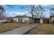Charming ranch-style home with brick accents and an attached carport on a sunny day at 1611 Elmhurst Dr, Indianapolis, IN 46219