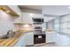 Well-equipped kitchen with stainless steel appliances, white cabinets, and butcher block countertops at 1611 Elmhurst Dr, Indianapolis, IN 46219