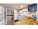 Bright kitchen featuring stainless steel refrigerator, white cabinetry, and stylish butcher block countertops at 1611 Elmhurst Dr, Indianapolis, IN 46219