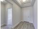 Bright hallway featuring hardwood floors, tray ceiling, and white trim for a clean, modern look at 16799 Imperial Ct, Fishers, IN 46040