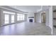 Bright living room featuring wood floors, fireplace with stone surround and French doors leading to the backyard at 16799 Imperial Ct, Fishers, IN 46040
