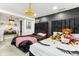 Bedroom with two beds, black accent wall, overhead chandelier, and soft, plushy toys at 1750 Quiet Haven Cir, Indianapolis, IN 46229