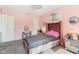 Pink bedroom featuring a tufted headboard, vanity desk, and decorative accents at 1750 Quiet Haven Cir, Indianapolis, IN 46229