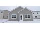 A light gray house with white trim in a snow-covered backyard. Includes a door and two windows at 1841 James Pierce Dr, Shelbyville, IN 46176