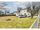 View of the home's backyard, featuring a fire pit, wooden deck, and a well-maintained lawn at 19 Orchard Ln, Anderson, IN 46011
