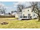 View of the home's backyard with its yellow siding, a wooden deck, and an outdoor fire pit at 19 Orchard Ln, Anderson, IN 46011