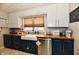 Charming kitchen featuring blue cabinets, wood countertops, and stainless steel dishwasher at 19 Orchard Ln, Anderson, IN 46011