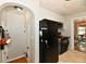 View of the kitchen showing black appliances and tile flooring leading into the dining room at 19 Orchard Ln, Anderson, IN 46011
