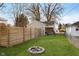 View of the backyard featuring green grass, a new fence, and a built-in firepit at 218 E Carlisle St, Mooresville, IN 46158