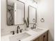 Modern bathroom features a double sink vanity, stylish mirrors, and a glass-enclosed shower at 220 Pine Dr, Indianapolis, IN 46260