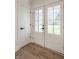 Bright foyer featuring a white door, hardwood floors, and natural light from the exterior doors at 220 Pine Dr, Indianapolis, IN 46260