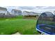 A fenced backyard with a trampoline and other residences visible beyond a line of trees at 2336 Boneset Dr, Plainfield, IN 46168