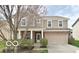 Charming two-story home with brick and beige siding, a covered porch, and an attached two-car garage at 2336 Boneset Dr, Plainfield, IN 46168