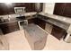 Kitchen featuring dark cabinets, stainless steel appliances, an island, and tile flooring at 2336 Boneset Dr, Plainfield, IN 46168