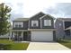 Charming two-story home featuring a manicured lawn, gray siding, white trim, and a two-car garage at 2913 W Broderie Ln, Monrovia, IN 46157